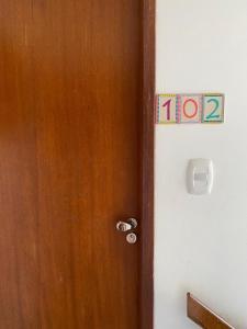 a wooden door with a sign on the side of it at Apartamento 102 no Vivendas do Serrano em Lençóis in Lençóis