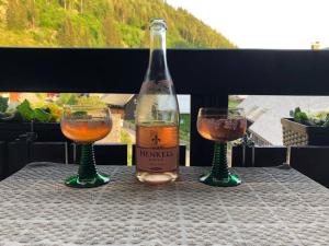 a bottle of wine and two glasses on a table at Forest Apartment in St. Blasien