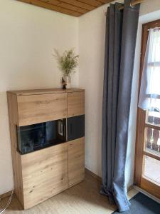 a living room with a wooden entertainment center and a window at Forest Apartment in St. Blasien