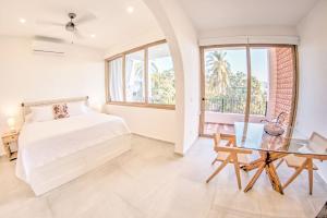- une chambre avec un lit et une table en verre dans l'établissement Estadios Suites - Only 3 Blocks to Beach, à Bucerías