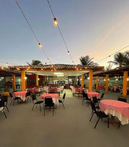 eine Außenterrasse mit Tischen und Stühlen sowie ein Restaurant in der Unterkunft IMPERIAL AREMBEPE BEACH in Arembepe