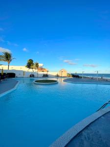 basen z niebieską wodą przed plażą w obiekcie IMPERIAL AREMBEPE BEACH w mieście Arembepe