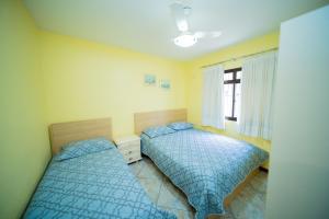 a bedroom with two beds and a window at Edificio Martha Schwantz in Guarapari