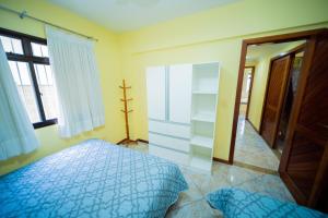 a bedroom with a blue bed and a closet at Edificio Martha Schwantz in Guarapari