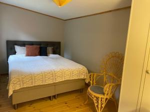 a bedroom with a bed and a chair at Stuga Sövde in Sövde
