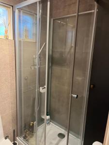 a shower with a glass door in a bathroom at Stuga Sövde in Sövde