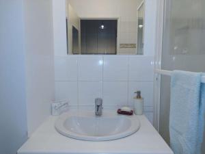 uma casa de banho branca com um lavatório e um espelho em Puteaux - PARIS LA DEFENSE em Puteaux