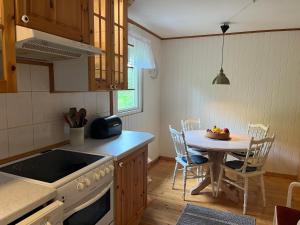 a kitchen with a table and a dining room at Stuga Sövde in Sövde +7 photos