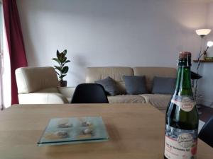uma garrafa de vinho sentada numa mesa com um prato de dunas no topo em Puteaux - PARIS LA DEFENSE em Puteaux