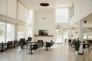 un comedor con mesas, sillas y ventanas en Hotel Posta del Sol Paraná en Paraná