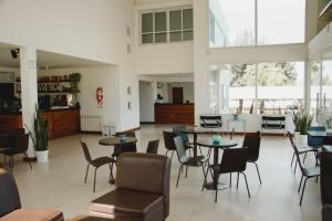 Habitación grande con mesas, sillas y ventanas. en Hotel Posta del Sol Paraná en Paraná