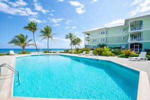 a swimming pool in front of a building and the ocean at On the Bay #103 Condo in Old Man Bay