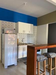 a kitchen with a white refrigerator and a counter at Apartamento 02 no Vivendas do Serrano em Lençóis in Lençóis
