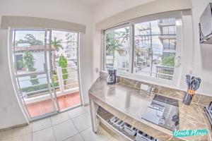a kitchen with large windows and a counter top at Madison - 99 Steps to Beach in Golden Zone in Bucerías