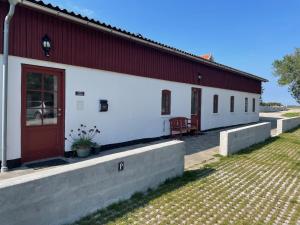 a red and white building with a red door at Vita og Pouls Gård - Guesthouse in Viby