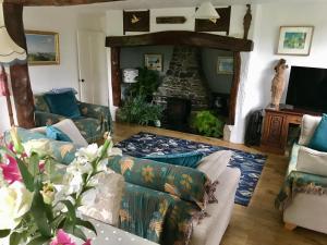 a living room with a couch and a fireplace at Fuchsia Cottage in Porthallow