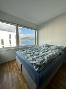 a bedroom with a bed and a large window at Seaside panorama in Tromsø