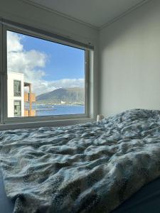 a bedroom with a large window looking out at the ocean at Seaside panorama in Tromsø