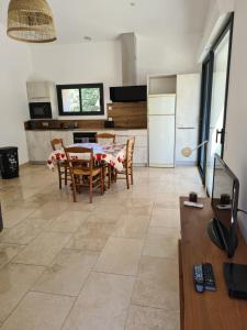 a kitchen and living room with a table and chairs at Maison en plein nature in Villemus