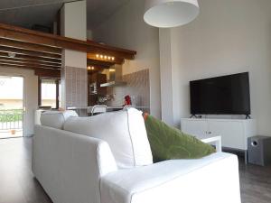 a living room with a white couch and a tv at IAROS El Coto in Mogro