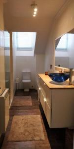 La salle de bains est pourvue d'un lavabo bleu et de toilettes. dans l'établissement IAROS El Coto, à Mogro