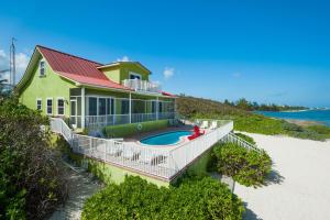 a house with a swimming pool on the beach at Parrot-ise 4 Bedroom Villa in Brinkleys