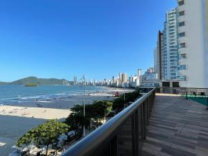 balcón con vistas a la playa y a los edificios en Apto Pé na Areia com Linda Vista da Roda Gigante, en Balneário Camboriú
