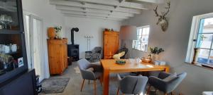 uma sala de estar com uma mesa de madeira e cadeiras em Casa Clérigo Espartal em Aljezur