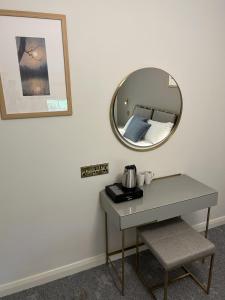 a table with a mirror next to a bed at Castle Irvine Estate in Irvinestown