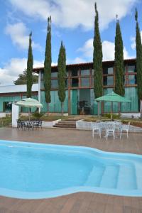 un hotel con piscina di fronte a un edificio di Village Recanto Splendory - Sítio com lazer completo e privativo perto de BH a Prudente de Morais