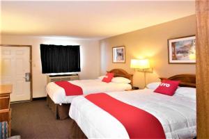 a hotel room with two beds with red pillows at OYO Hotel Guymon OK US-54 in Guymon