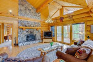 a living room with a stone fireplace in a cabin at Bend Getaway with Private Hot Tub and Cozy Fireplace in Bend