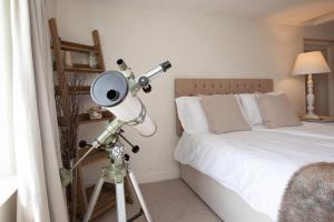 a bedroom with a telescope next to a bed at East Ayrlow Banks in Hauxwell