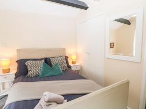 a bedroom with a large bed with a mirror at Rose Cottage in Castleton