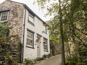 a stone house with a door and a window at Rose Cottage in Castleton