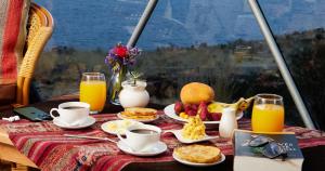 een ontbijttafel met ontbijtproducten en jus d'orange bij Titikaka Sky View in Juliaca