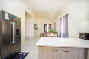 a kitchen with a stainless steel refrigerator and a living room at home with relaxing sea view in Discovery Bay