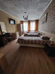 a bedroom with a large bed and a brick wall at Familia Apartments in Samokov