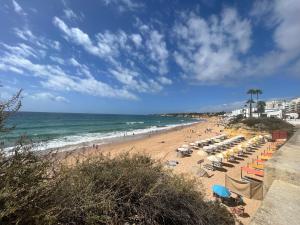een strand met een stel stoelen en de oceaan bij Sunset in Armação de Pêra