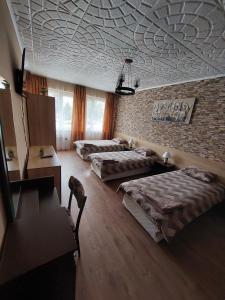 a bedroom with three beds and a brick wall at Familia Apartments in Samokov