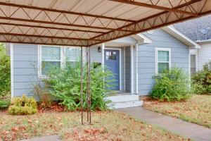a house with a blue door and a wooden pergola at Updated Mangum Home about 14 Mi to Quartz Mountain! in Mangum