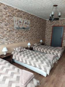 two beds in a room with a brick wall at Familia Apartments in Samokov