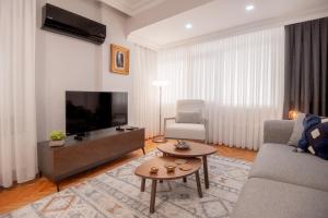 - un salon avec un canapé, une télévision et une table dans l'établissement Charming Bagdat Avenue Hideaway, Near Marina, à Istanbul