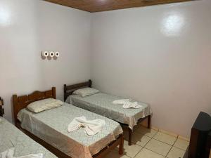 a room with two beds with towels on them at Hotel Cristo Redentor in Jataí