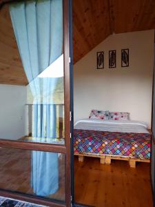 een slaapkamer met een bed in een kamer met een raam bij Happy days house in Shuakhevi