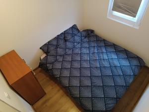 een bed met een blauw en wit dekbed in een kamer bij Radusha Open 