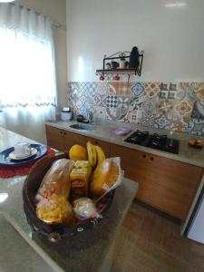 un tazón de pan y plátanos en una barra en una cocina en Pousada Casa no Sitio en Santa Teresa