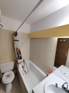een badkamer met een bad, een toilet en een wastafel bij La Mongie pied des pistes in La Mongie