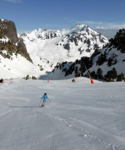 een persoon is aan het skiën in een met sneeuw bedekte berg bij La Mongie pied des pistes in La Mongie