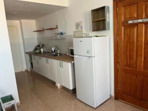 a kitchen with a white refrigerator and a sink at La Vista Bonita in Corralejo